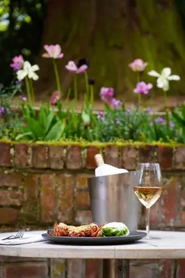 a plate of food and a glass of wine on a table at Milsoms in Dedham