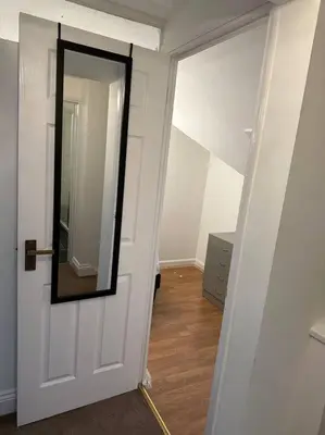 a hallway with a mirror on the door at Spacious 4 bedroom house in Billericay