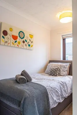 a bedroom with a bed and a painting on the wall at 2 Bedroom Rural Escape In Peaceful Elmswell in Woolpit
