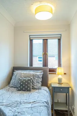 a bedroom with a bed with a lamp and a window at 2 Bedroom Rural Escape In Peaceful Elmswell in Woolpit