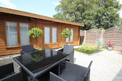 a patio with a table and chairs and a building at The Zen Den in Southend-on-Sea