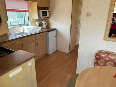 a small kitchen with a sink and a table at Rohannah Luxe Coastal Escape, Cooper Beach East Mersea in East Mersea