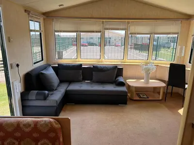 a living room with a couch and some windows at Rohannah Luxe Coastal Escape, Cooper Beach East Mersea in East Mersea