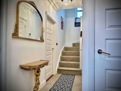 a hallway with a blue door and a mirror at 5 Bedroom House - DISC0UNTS - Parking, Contractors, Group, Family in Braintree