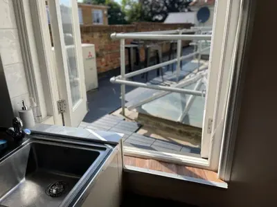 a kitchen with a sink and a view of a balcony at SmithStayz Apartments Epping in Epping