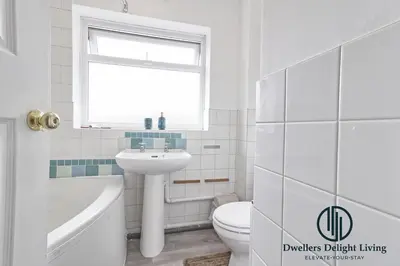 a white bathroom with a sink toilet and a window at Purple Velvet - 2 Bed Home Spacious - Basildon Essex Upto 5 Guests, Free Wifi , Free Parking in Basildon