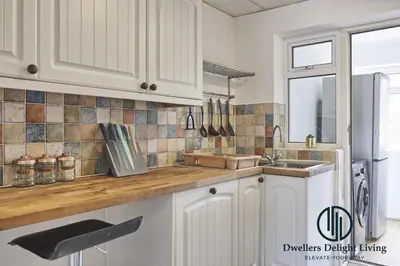 a kitchen with white cabinets and a sink at Purple Velvet - 2 Bed Home Spacious - Basildon Essex Upto 5 Guests, Free Wifi , Free Parking in Basildon