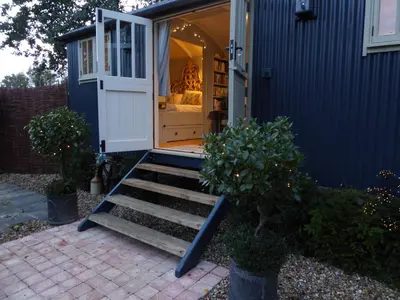 a tiny house with stairs leading to a door at Utopia in Harleston