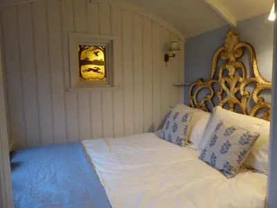 a bed with white sheets and blue pillows in a room at Utopia in Harleston