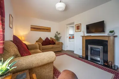 a living room with a couch and a fireplace at Escape in Aldeburgh