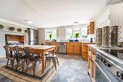 a large kitchen with a wooden table and chairs at 5 Bed Farmhouse Suitable for Contractors Private Parking in Potter Street
