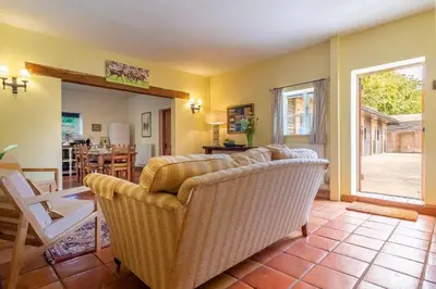 a living room with a couch and a table at Stable Cottage in Semer