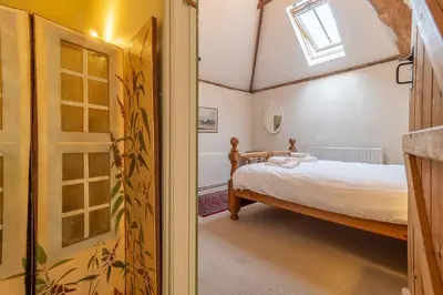 a bedroom with a bed and a window at Stable Cottage in Semer