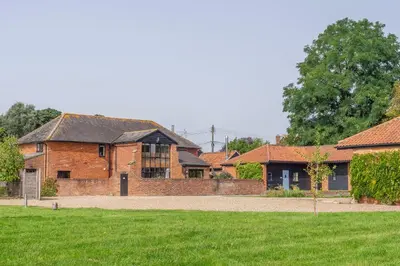 an old brick house with a yard and grass at The Old Barn in Semer