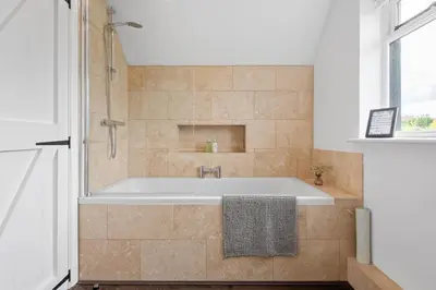 a bath tub in a bathroom with a window at Attractive 2 storey, 2 bedroom barn in Long Melford in Long Melford