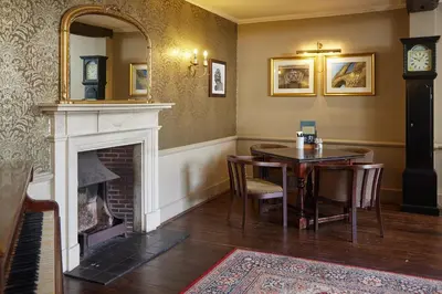 a dining room with a table and a fireplace at Bell by Greene King Inns in Thetford