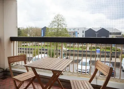 a wooden table and two chairs sitting on a balcony at Bell by Greene King Inns in Thetford