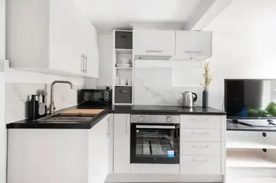 a white kitchen with a sink and a stove at Nice 2 bedroom house in Stowmarket in Stowmarket