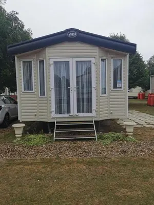 a tiny house with a staircase in a yard at Happy Place in West Mersea