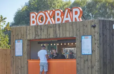 a man standing in front of a box bar at Brand New Modern Holiday Home - Haven The Orchards Holiday Park in Saint Osyth