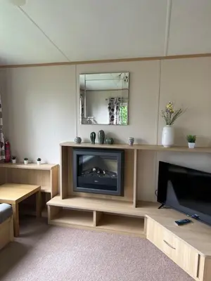 a living room with a flat screen tv and a tv stand at Lovely place in Saint Osyth
