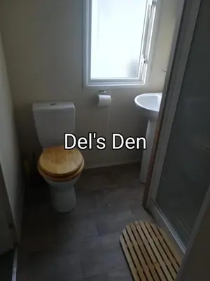a bathroom with a toilet and a sink and a window at Del's den lakeside weeley bridge in Weeley