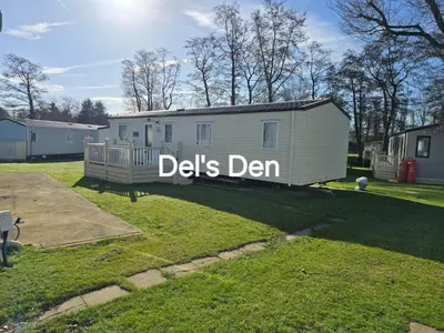 a mobile home with a sign that reads delks den at Del's den lakeside weeley bridge in Weeley