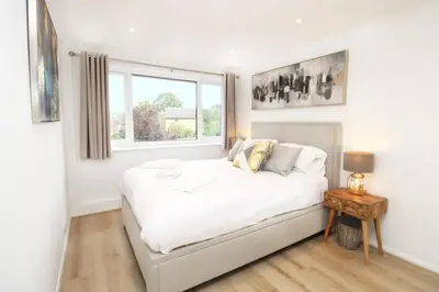a bedroom with a large white bed with a window at Modern and Cosy Flat For 4 in Cherry Hinton