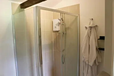 a shower with a glass door in a bathroom at The Lodge - 2 acres of garden with hot tub and fire pit and BBQ in East Harling