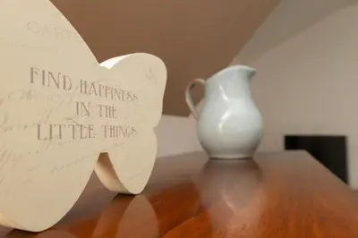 a white vase sitting on a table with a piece of paper at The Thatched Flat at The Sorrel Horse in Shottisham