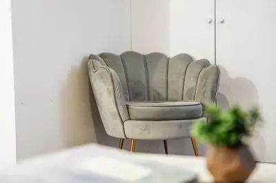a gray chair in a room with a table at Comfortable 4-BDR House, Sleeps 7, WIFI, Secure Parking in Cambridge