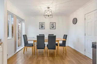 a dining room with a wooden table and chairs at Comfortable 4-BDR House, Sleeps 7, WIFI, Secure Parking in Cambridge