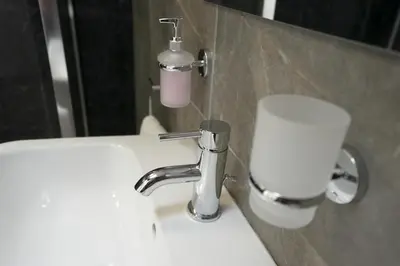 a bathroom sink with a faucet next to a mirror at The Den - KING BED, 5 min walk to City Centre in Cambridge