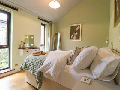 a bedroom with a bed with white sheets at 256 London Road in Colchester