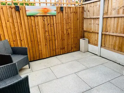 a patio with two chairs and a wooden fence at The Annex in Southend-on-Sea