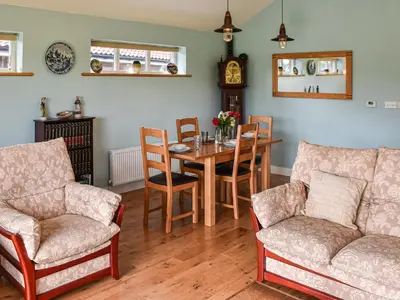 a dining room with a table and chairs at Cedar Lodge in Old Buckenham