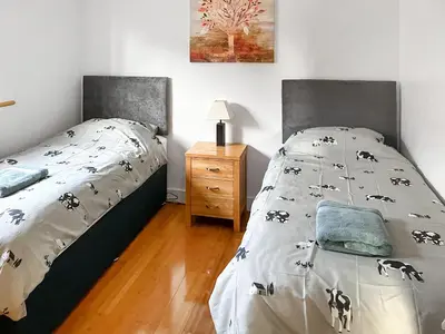 a bedroom with a bed and a nightstand with a bed sidx sidx at Cedar Lodge in Old Buckenham