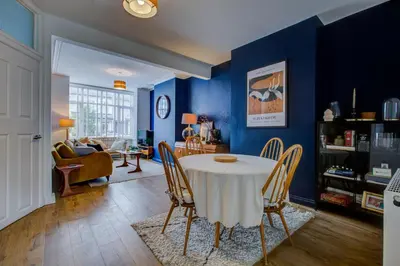 a dining room with a white table and chairs at Cosy house on the seafront - Pass the Keys in Southend-on-Sea