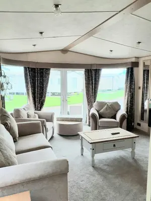 a living room with couches and a coffee table at The James Lodge in Little Clacton