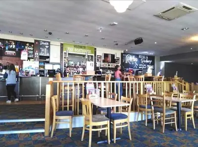 a restaurant with tables and chairs and a bar at The James Lodge in Little Clacton