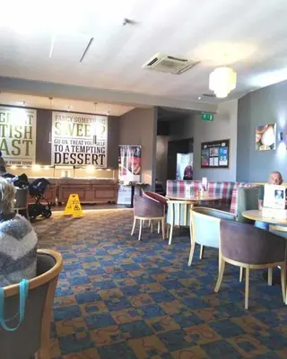 a restaurant with chairs and tables and a waiting room at The James Lodge in Little Clacton