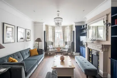 a living room with a couch and a table at Beautiful Spacious Beach Home Newly Renovated in Felixstowe