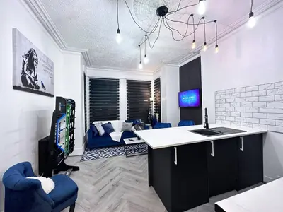 a room with a kitchen with blue chairs and a living room at Swanky Seaside Sanctuary w foozeball - Southend in Southend-on-Sea