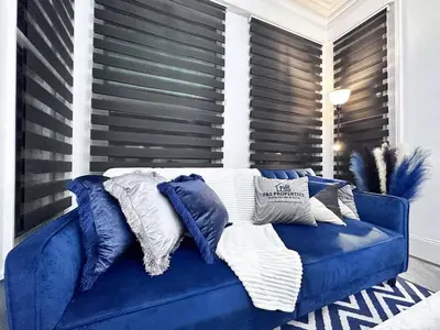 a blue couch with pillows on it in a room at Swanky Seaside Sanctuary w foozeball - Southend in Southend-on-Sea