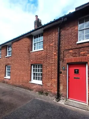 a red brick building with a red door at Kingfisher Cottage - Woodbridge in Woodbridge