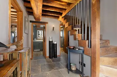 a hallway with wooden ceilings and a staircase at Bailiffs Cottage in Colchester