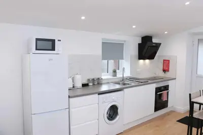 a white kitchen with a washer and dryer at Suffolk Cosy Corner with free parking, 10min walking to town centre in Bury Saint Edmunds
