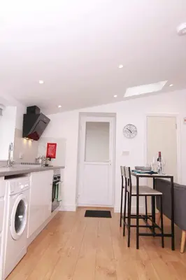 a kitchen with a table and a washing machine at Suffolk Cosy Corner with free parking, 10min walking to town centre in Bury Saint Edmunds