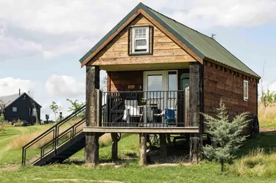 a tiny house with a porch and a deck at Lake View Lodges The Melford in Long Melford