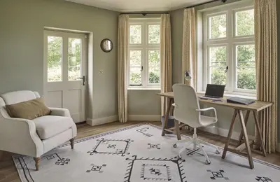 a living room with a desk and chairs and windows at Bridge House at Woodhall Estate in Hertford